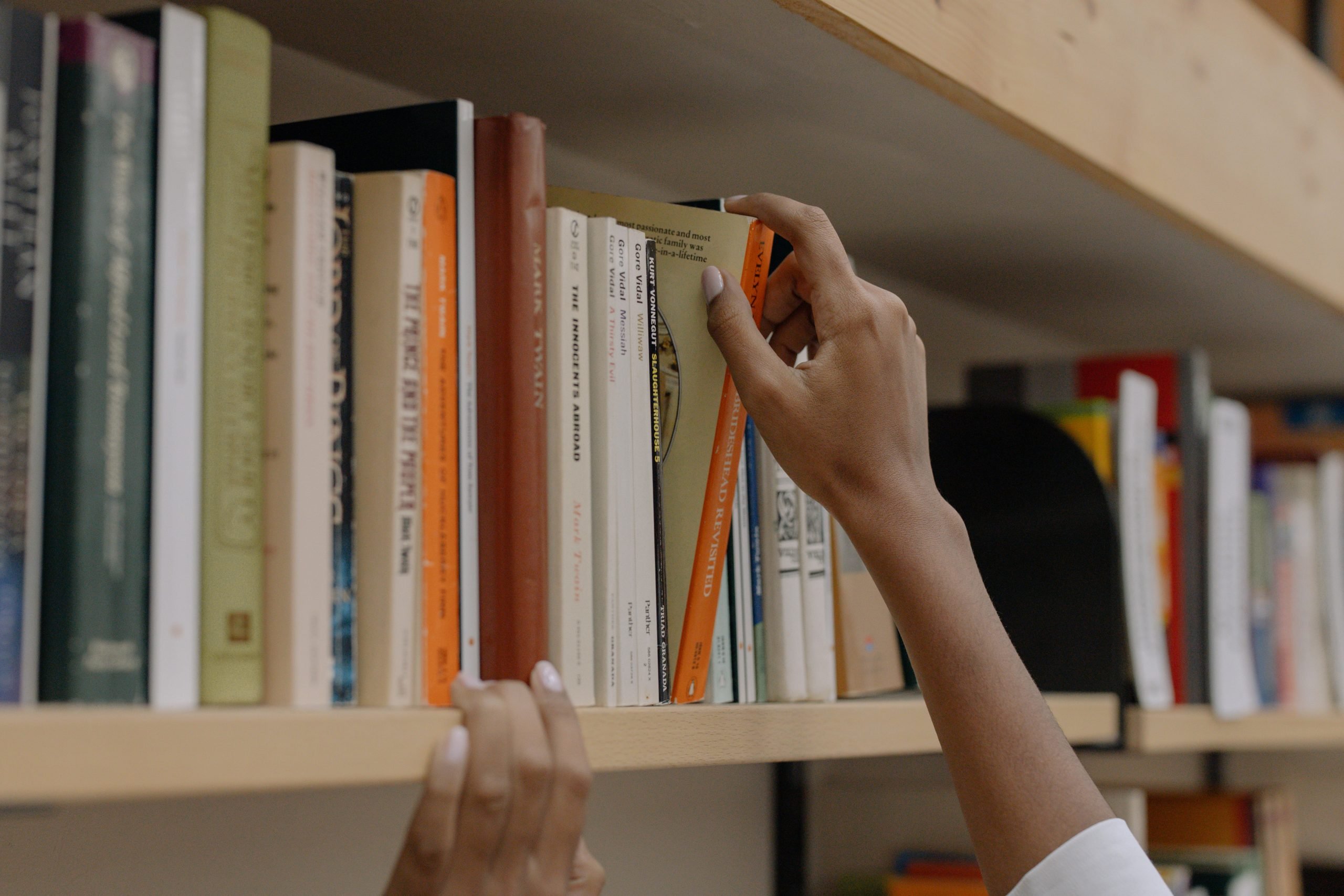 Student selecting a book off of a bookshelf