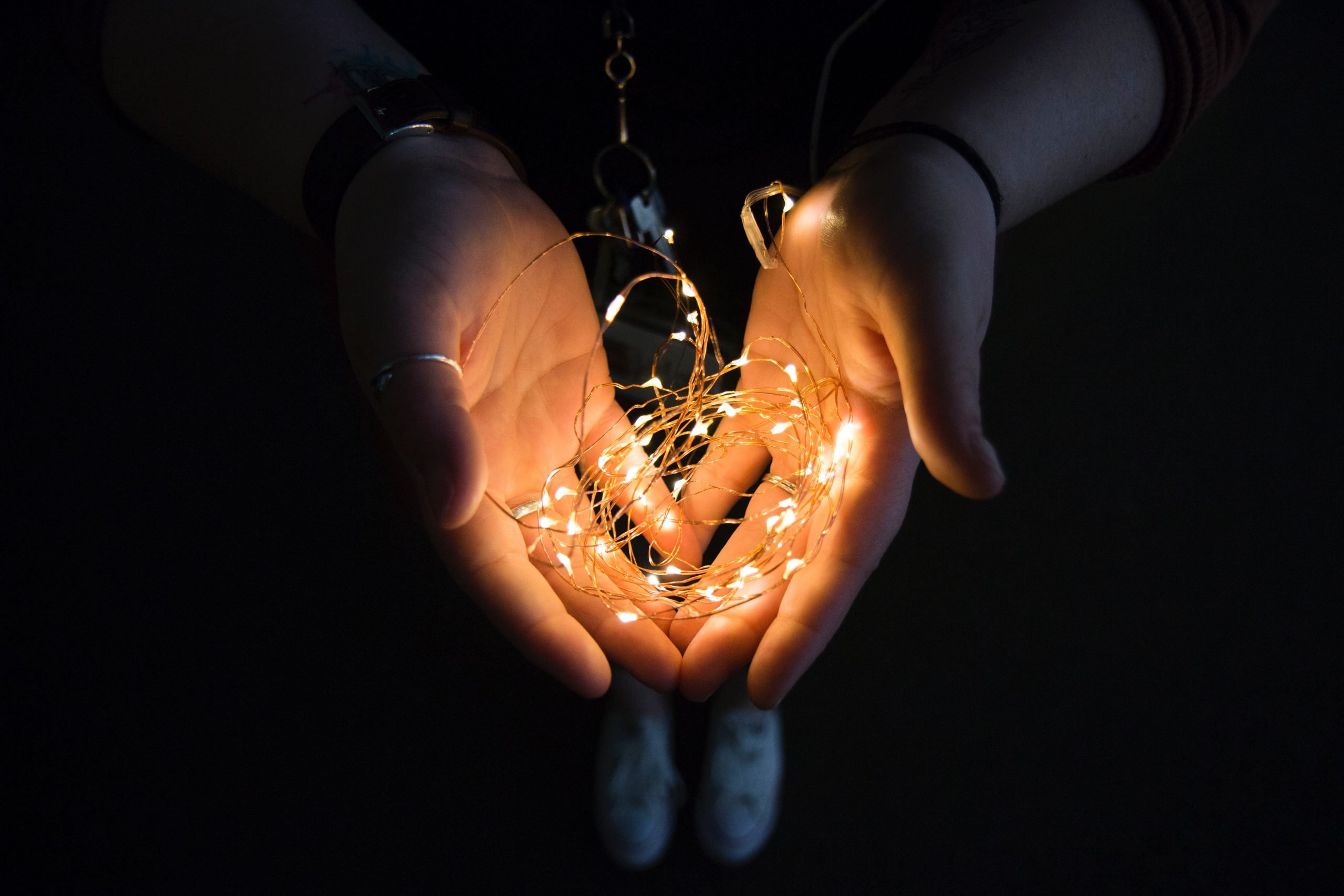 Person holding string of lights in their cupped hands