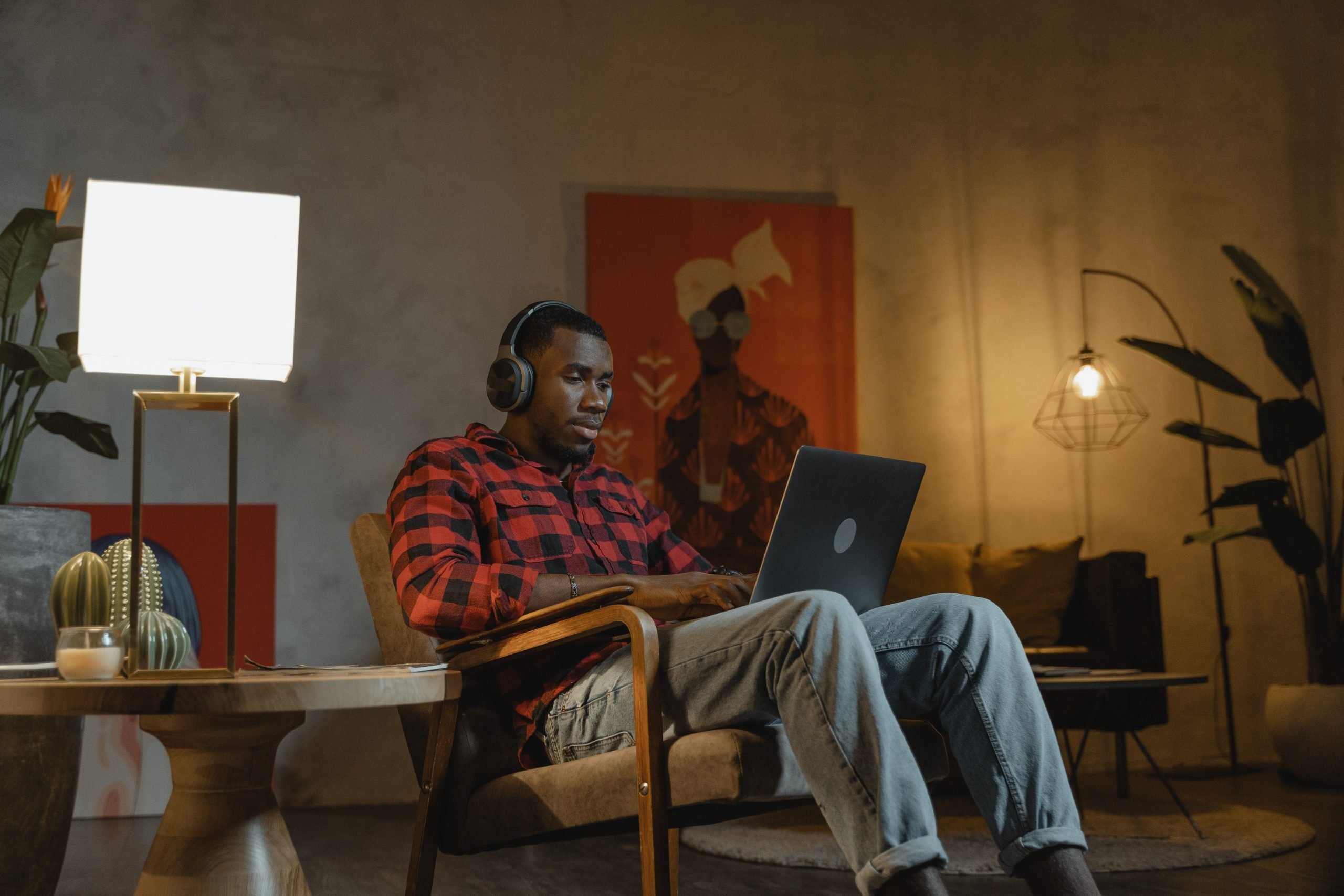 Young man studying at home with laptop and headphones